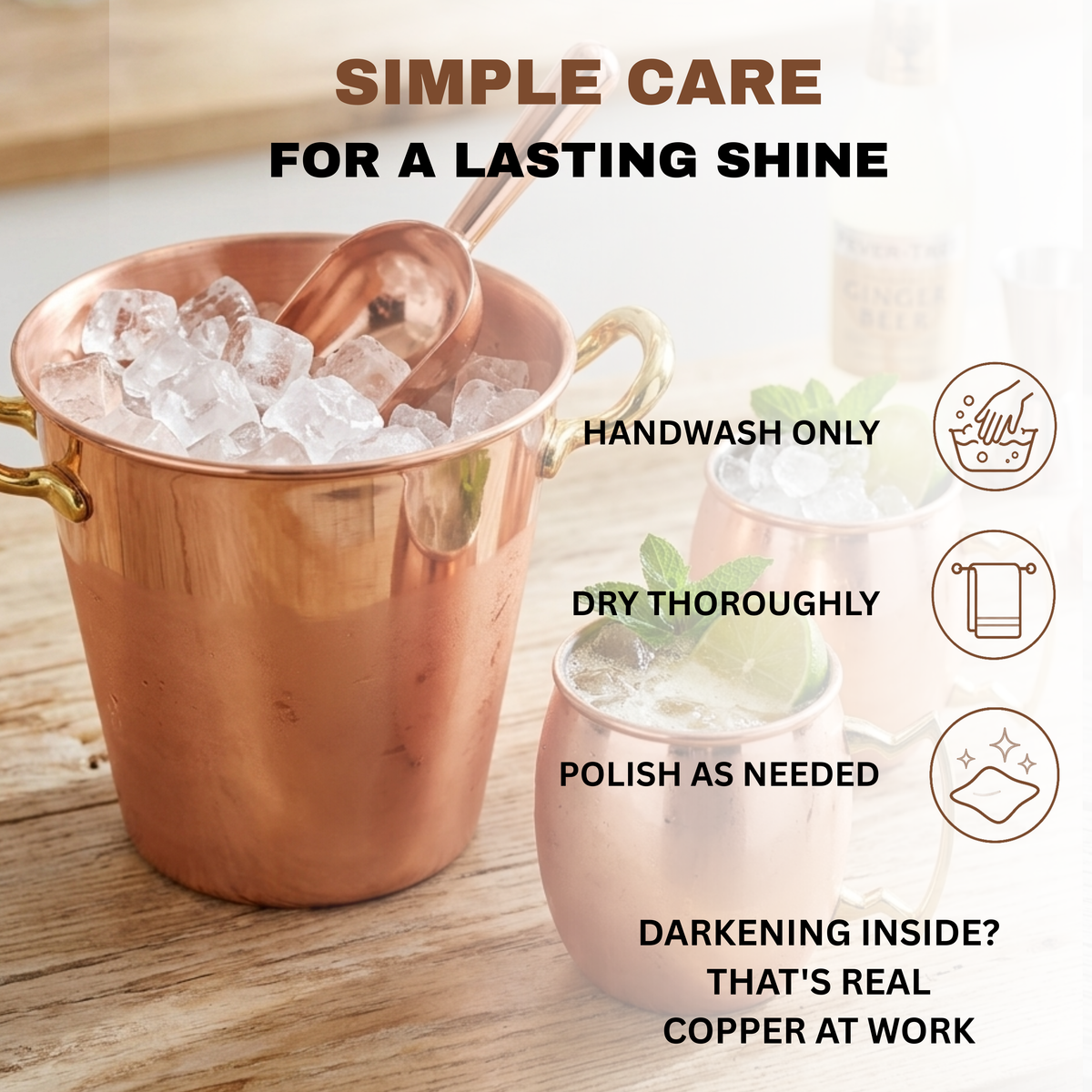 A copper bucket with smooth surface filled with ice on a wooden table, alongside copper mugs and care instructions text reading handwash only, dry thoroughly, and polish as needed.