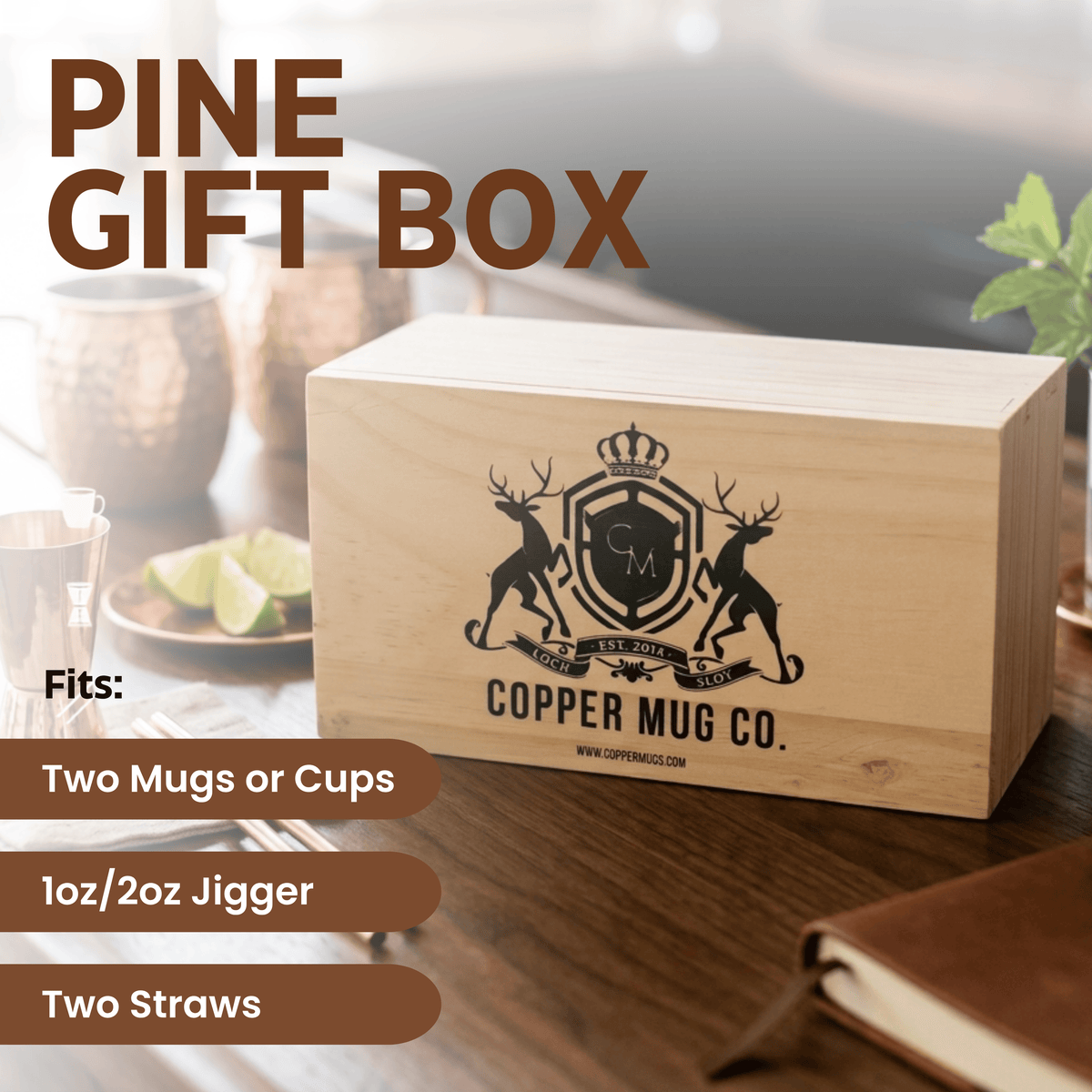 A light natural wood gift box engraved with the Copper Mug Co. crest and text, shown on a wooden table in a styled setting.