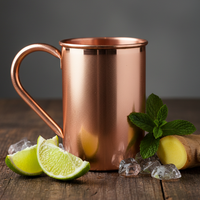 Solid copper mug with lime wedges and mint leaves on a wooden surface