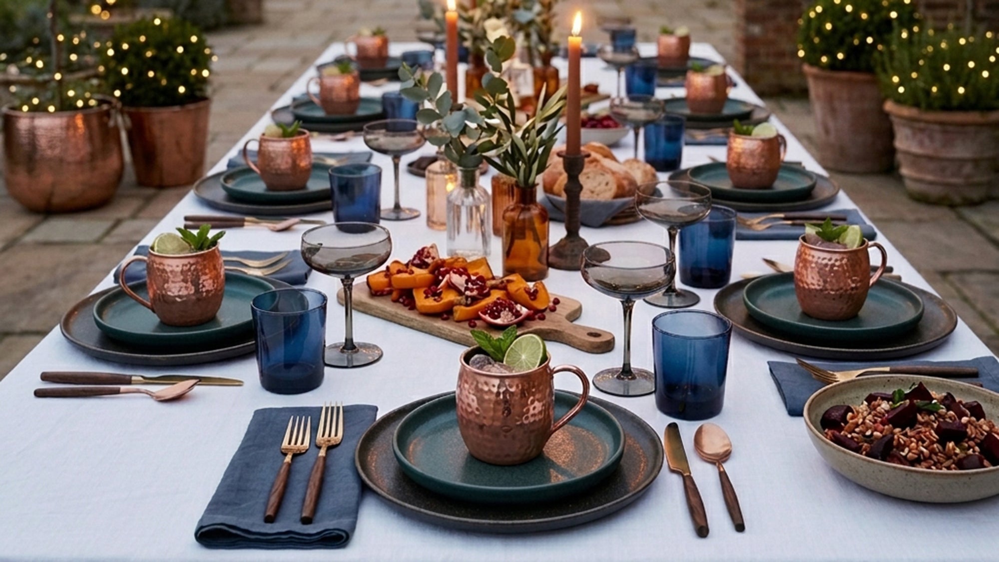 Elegant outdoor dining table setting with copper mugs as neutral decor